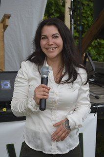 A past festival presenter speaking into a microphone